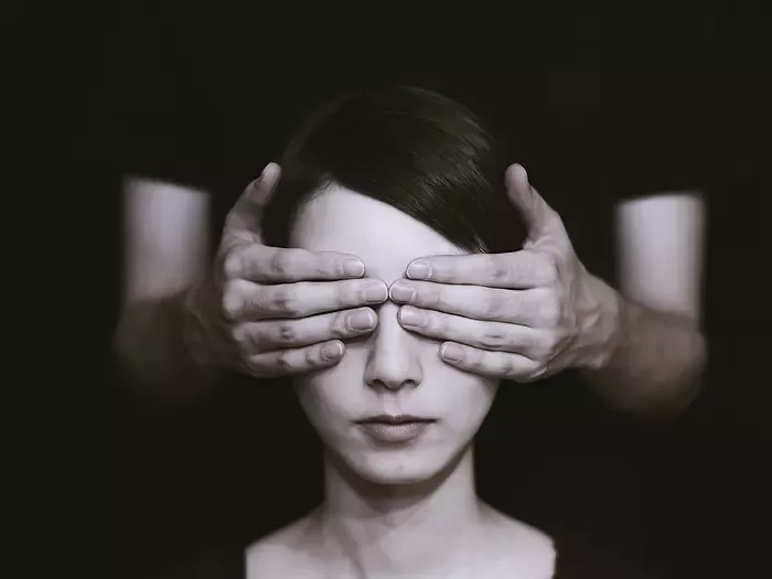 Frau mit zugehaltenen Augen